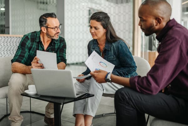 About Our Agency - Group Discussing Important Documents During a Meeting in the Office