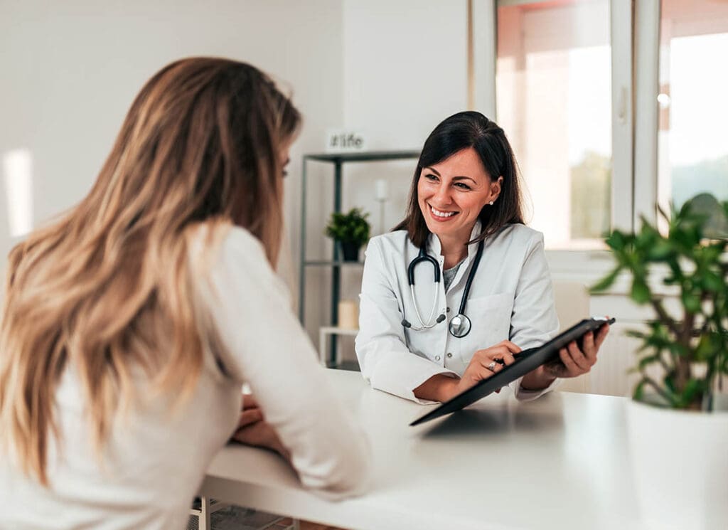 Health Insurance - Doctor Consulting Young Patient at the Doctors Office