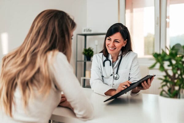 Health Insurance - Doctor Consulting Young Patient at the Doctors Office