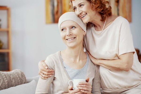 Critical Illness Insurance - Two Woman Staying Positive and Sitting Together at Home Enjoying Their Time Together after a Successful Radiation Therapy Session