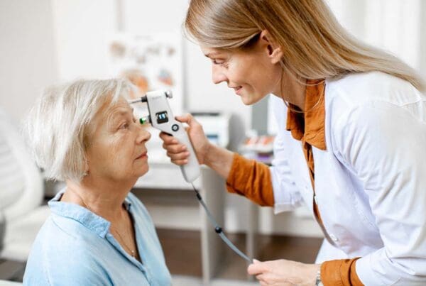 Dental, Vision, and Hearing Plans - Female Ophthalmologist Measuring the Eye Pressure with Modern Tonometer of a Senior Patient in the Medical Office
